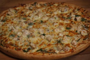 white pizza with chicken and fresh spinach